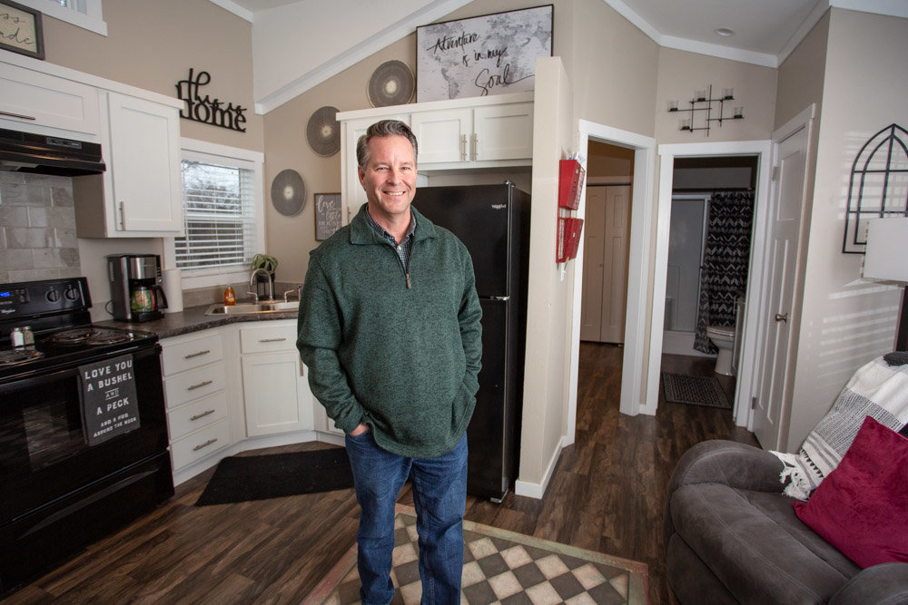 Harlan Hill stands inside one of Eden Village’s tiny residences designed to transition people out of homelessness.